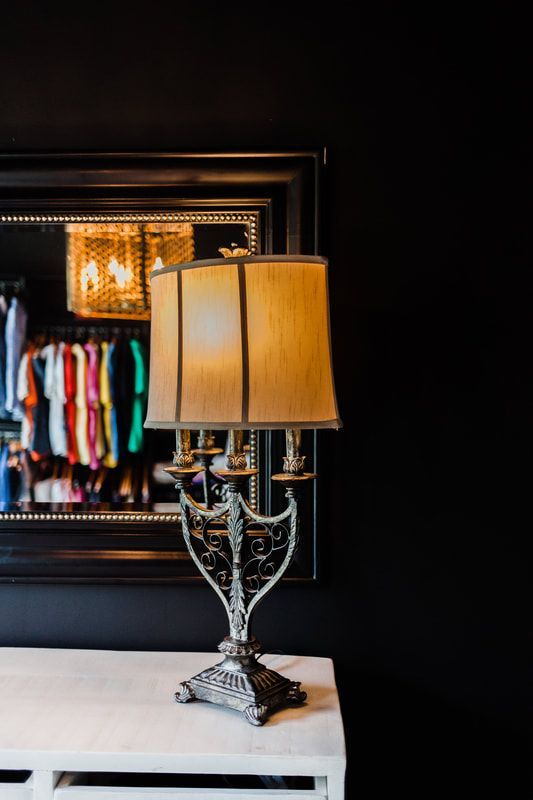 A lamp is sitting on a table in front of a mirror.