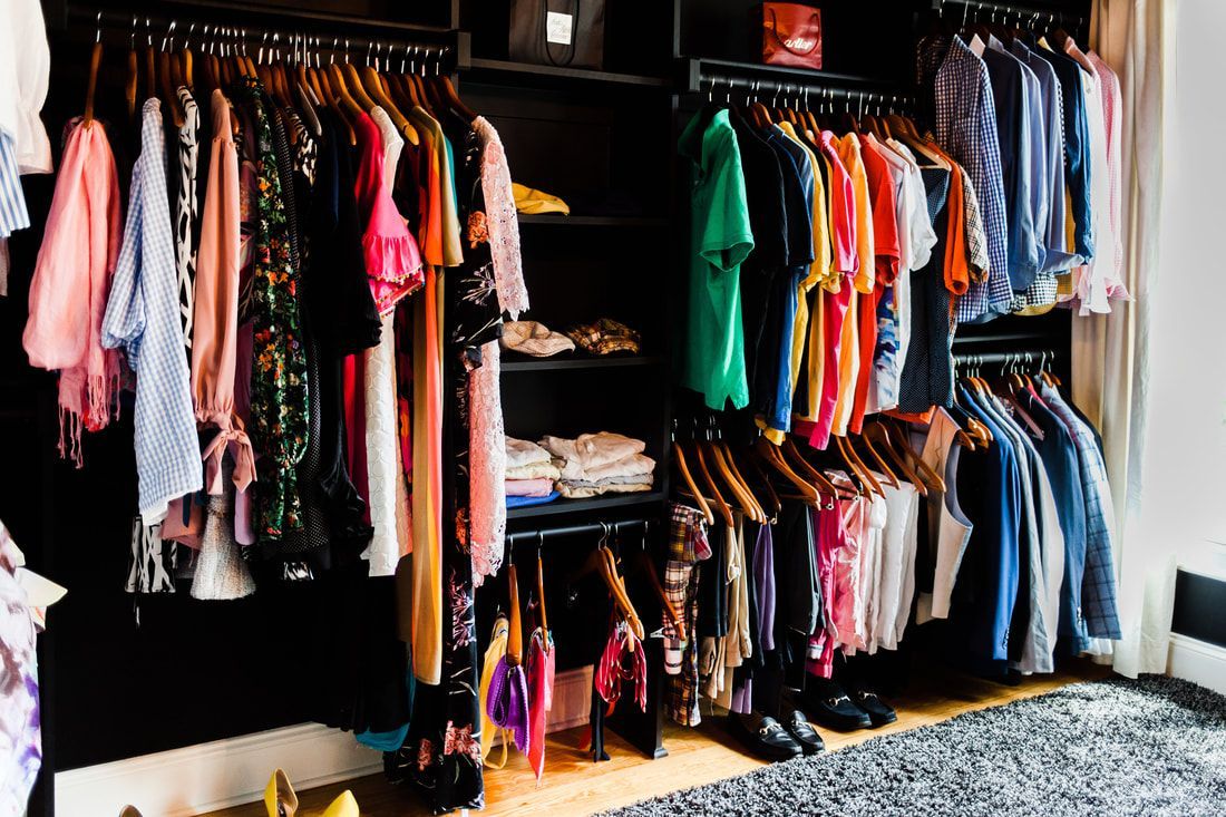 A closet filled with lots of clothes and shoes.