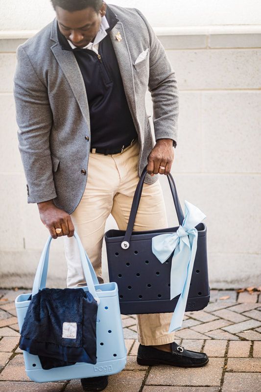 A man in a suit is holding two bags.