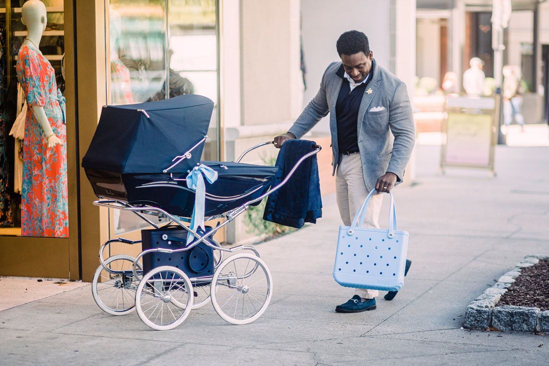 A man is pushing a stroller down a sidewalk.