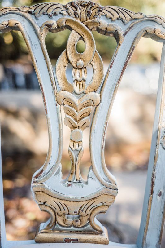 A close up of the back of a blue and gold chair.