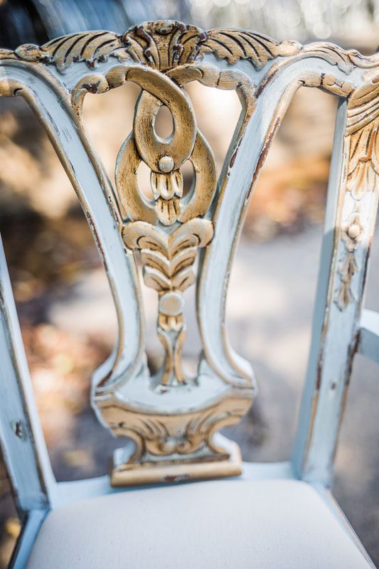 A close up of the back of a chair with a floral design on it.