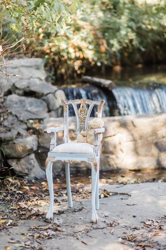 A white chair is sitting in front of a waterfall.
