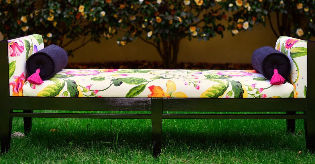 A bench with flowers on it is sitting in the grass.