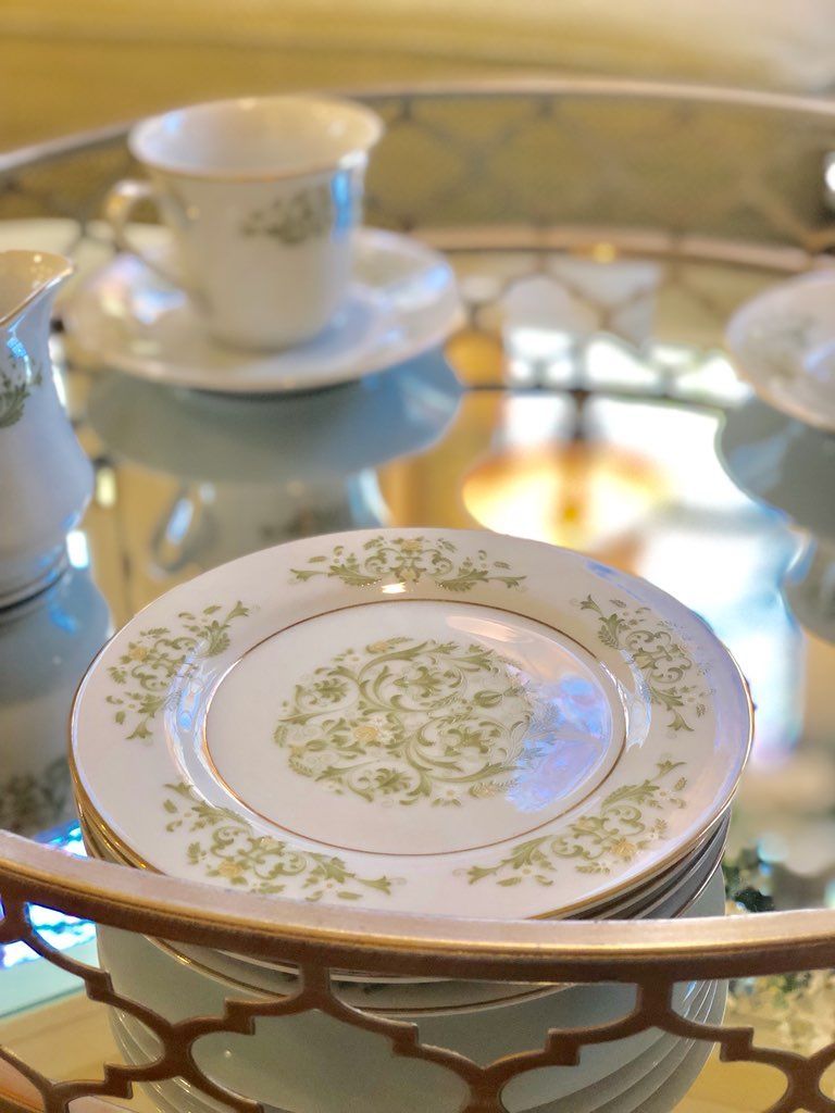 A stack of plates and cups on a glass table.