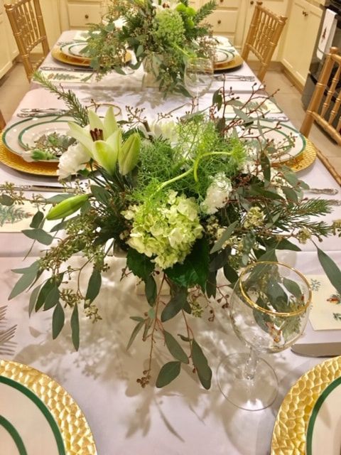 A table with plates and a vase of flowers on it