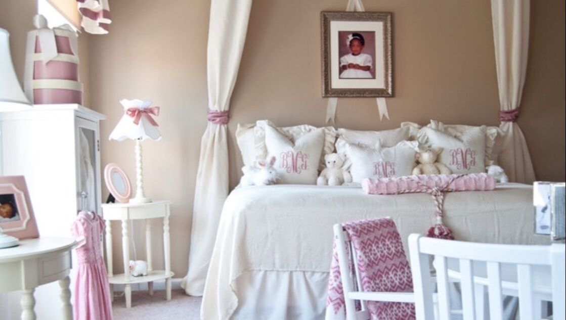 A bedroom with a canopy bed and a picture on the wall
