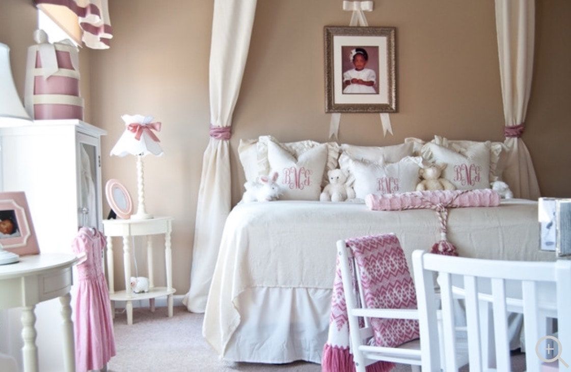 A girl 's bedroom with a canopy bed and a picture on the wall