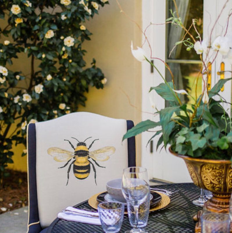 A chair with a bee embroidered on it