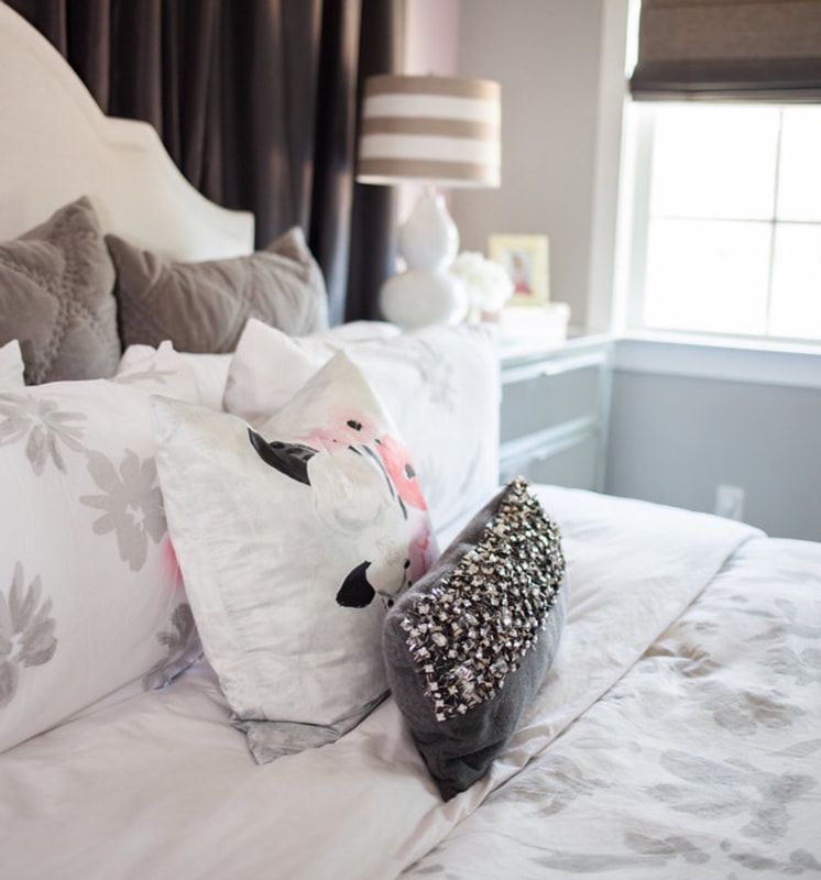 A bed with lots of pillows and a lamp