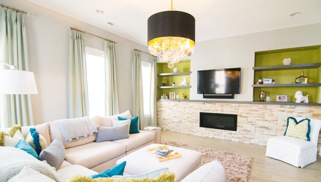 A living room with a couch , chairs , television and fireplace.