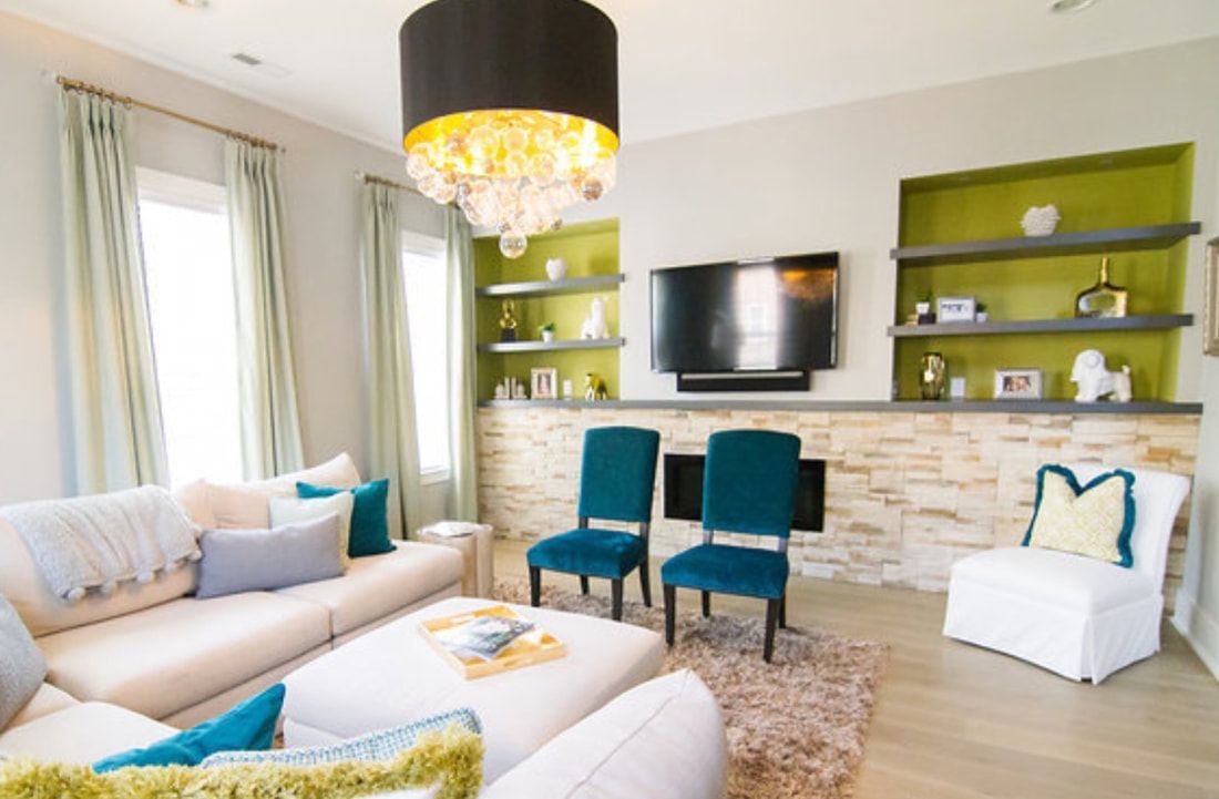 A living room with a couch , chairs , and a flat screen tv.