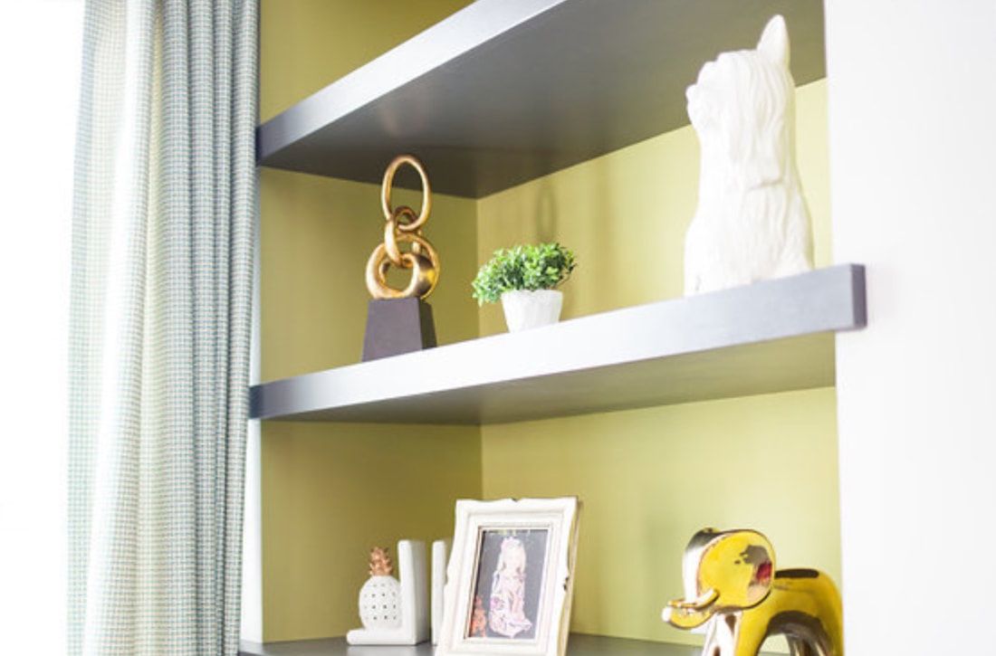 A shelf with a picture frame and a vase on it.