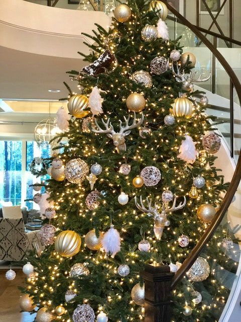A christmas tree is decorated with gold and silver ornaments