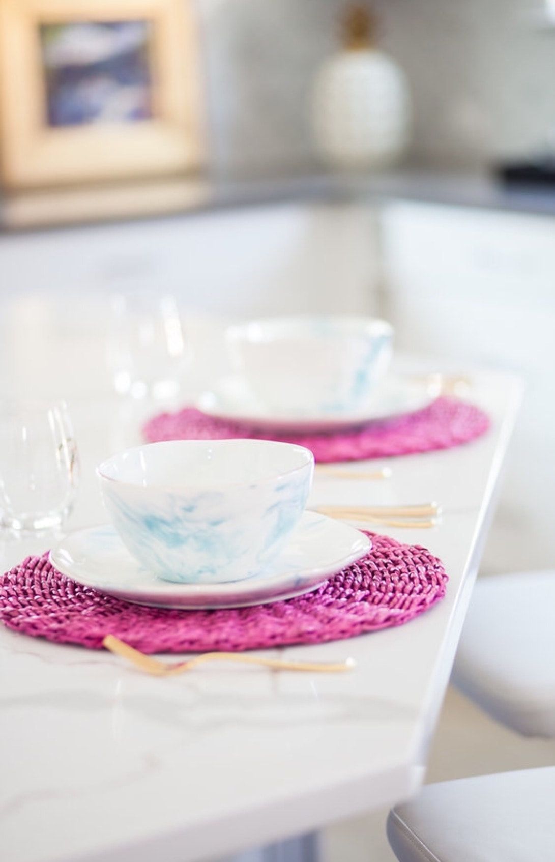 A table with plates , bowls , and chopsticks on it.