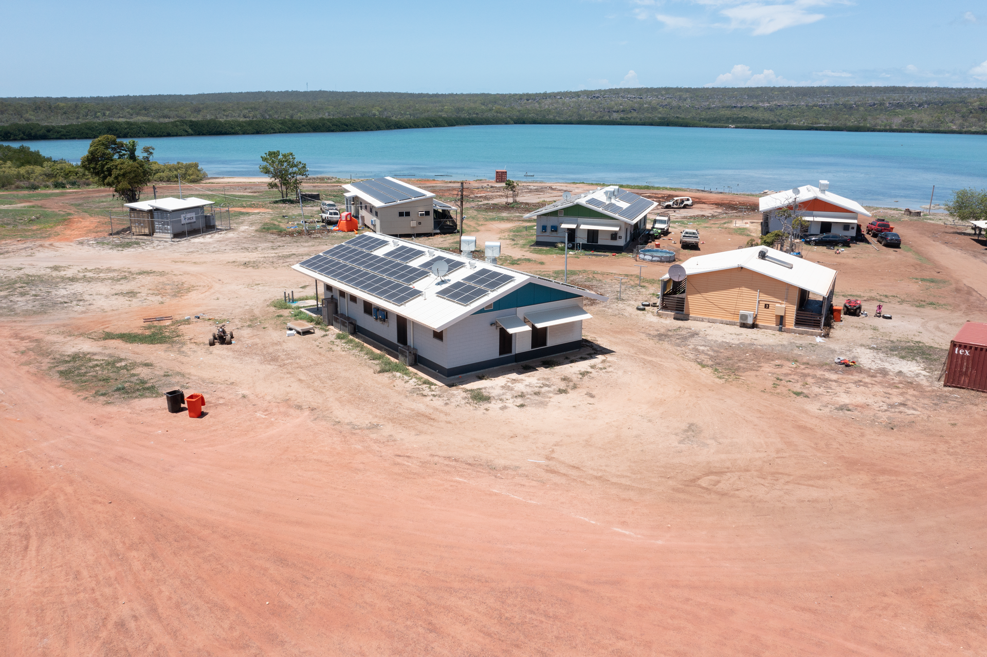 An aerial view of a group of houses next to a body of water.