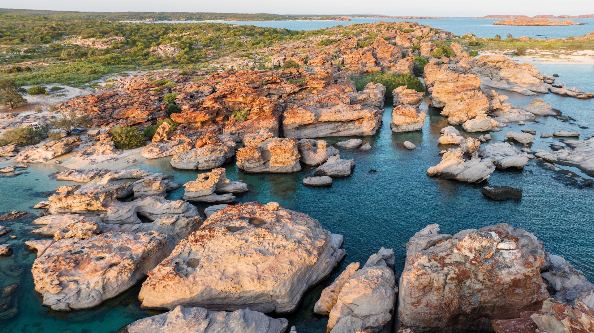 An aerial view of a rocky shoreline next to a body of water.