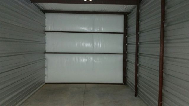 An empty storage unit with a white door