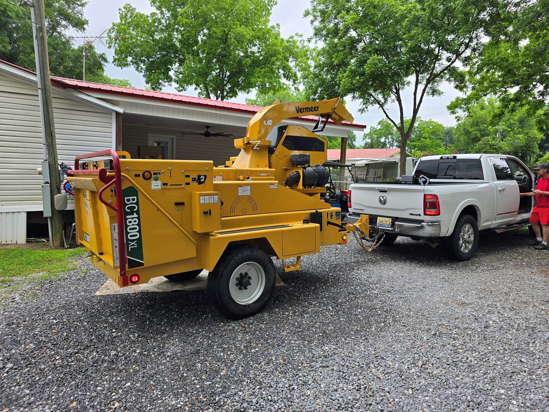 Two men are cutting a tree trunk with a chainsaw.