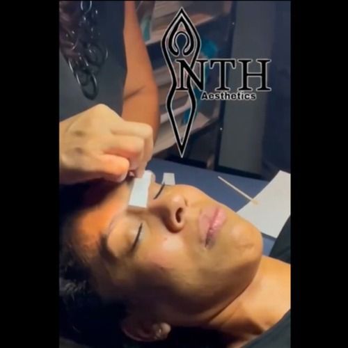 Person getting their eyebrow waxed at an aesthetics salon.