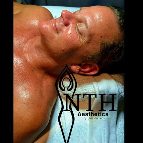 Man lying down with shiny skin after aesthetic treatment; logo visible.