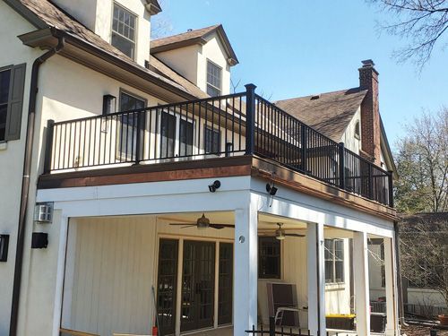 A white house with a balcony on the top of it