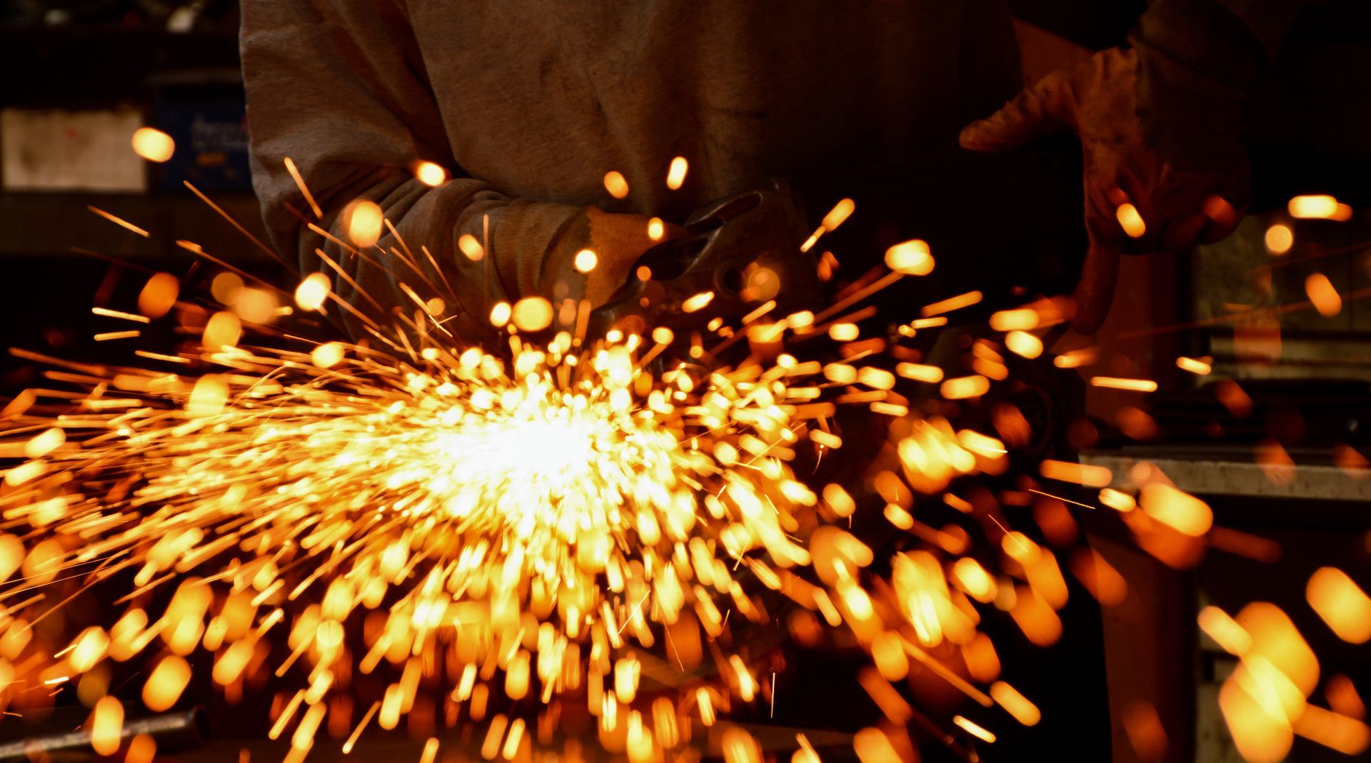 Close-up of welding with bright sparks and swirling blue smoke. 
