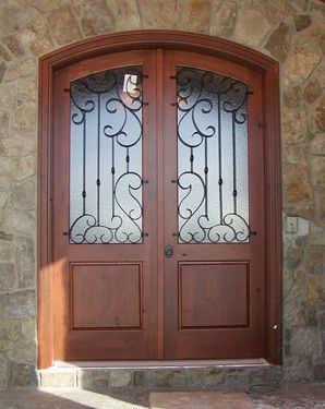 A wooden door with a wrought iron design on it