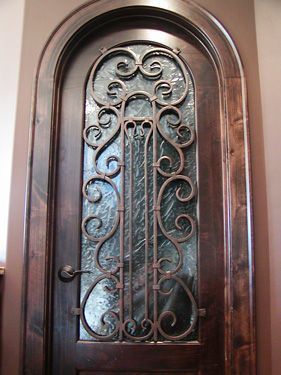 A wooden door with a wrought iron design on it