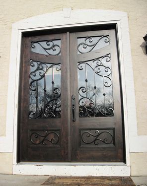 A wooden door with a wrought iron design on it