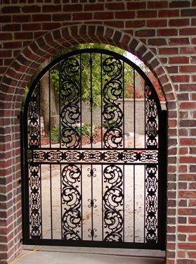 A wrought iron gate in a brick archway