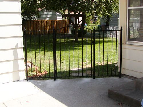 A white house with a black fence in front of it