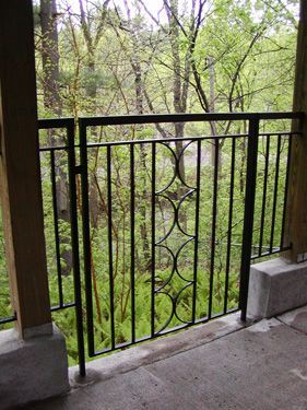 A balcony with a fence and trees in the background