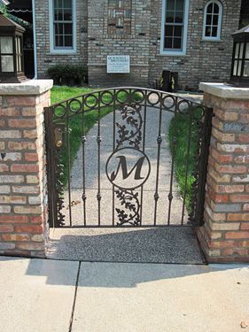 A wrought iron gate with the letter m on it