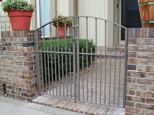 A brick wall with a metal gate in front of it