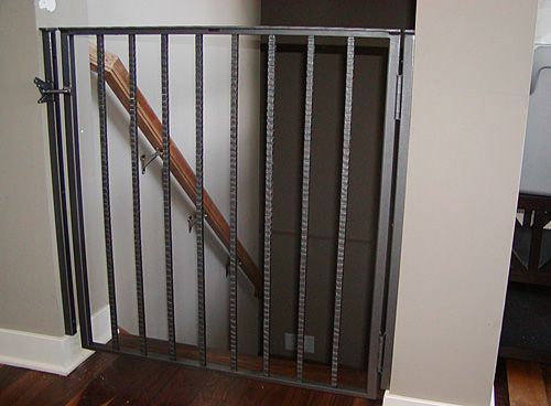 A staircase with a wrought iron railing and a wooden handrail