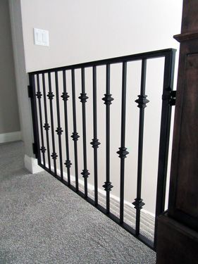A black wrought iron railing on a staircase in a house.