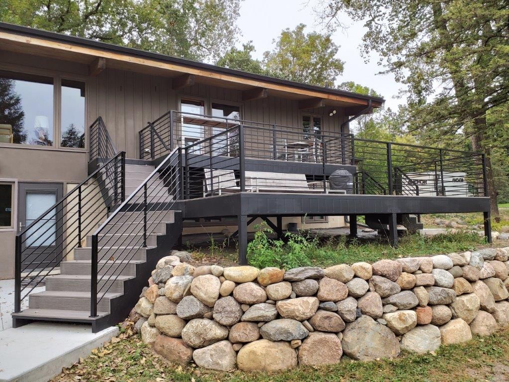 A house with a large deck and stairs leading up to it.