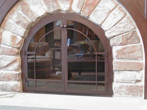 A living room with a fireplace and a screen door.