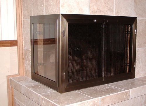 A fireplace with a screen and a glass door