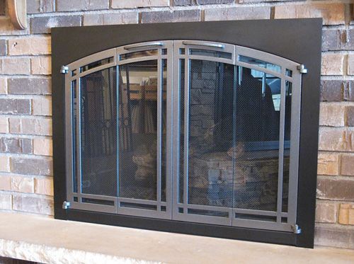 A fireplace with a screen and a brick wall behind it