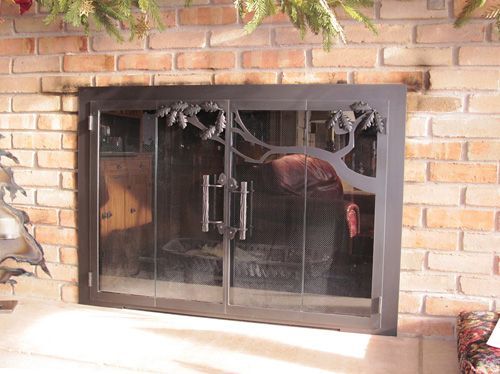 A fireplace with a glass door and a brick wall