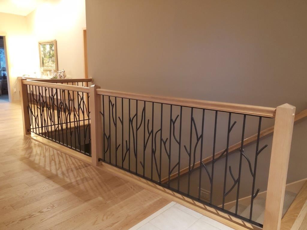 A staircase with a wooden railing and a metal railing.