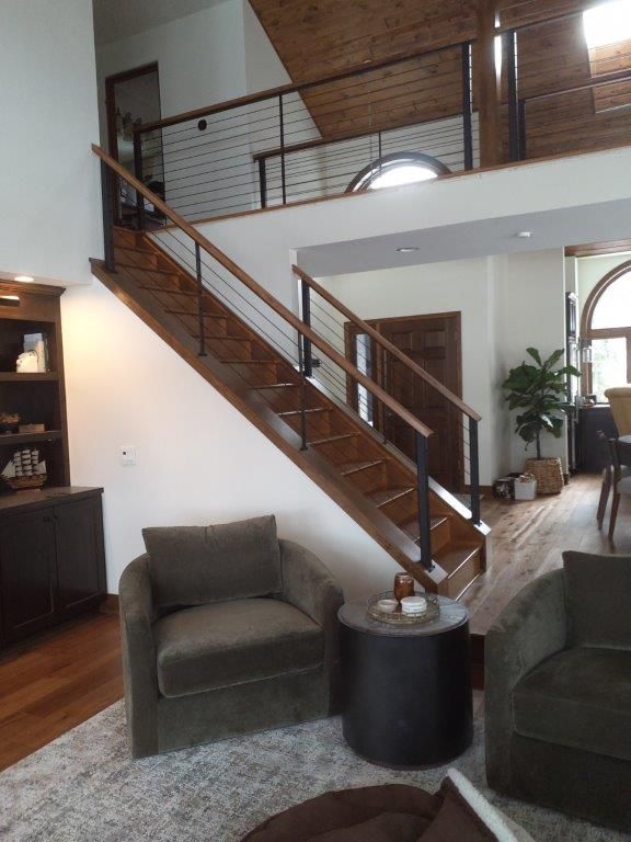 A living room with stairs leading up to the second floor