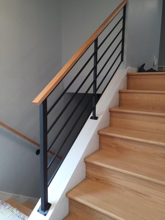 A staircase with wooden steps and a black railing