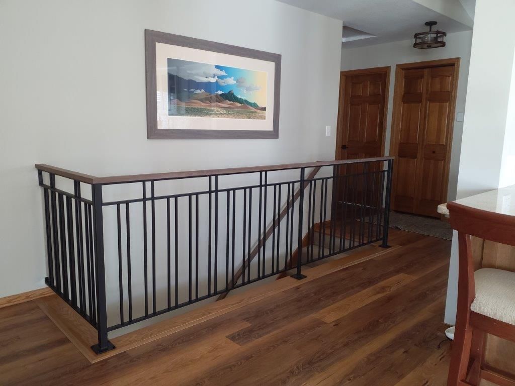 A staircase with a railing and a picture on the wall above it.