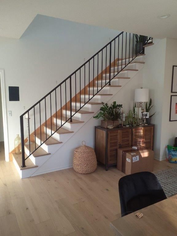 A living room with a staircase and boxes on the floor