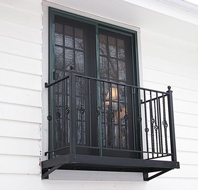 A balcony on the side of a house with a sliding glass door