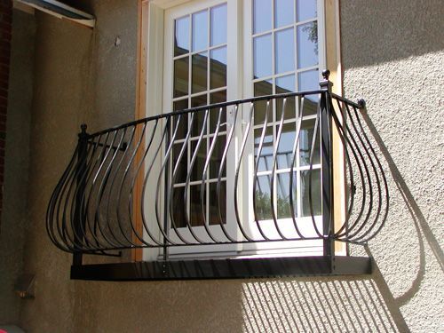 A balcony with a wrought iron railing on the side of a building
