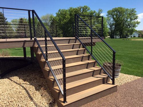 A set of stairs leading up to a deck with a metal railing.